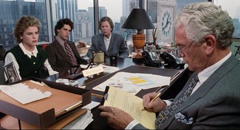 Movie still from “Reversal of Fortune” (1990), directed by Barbet Schroeder – Three people are sitting at a table in a room; Medium shot, Over the shoulder angle