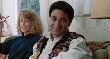 Movie still from “Reversal of Fortune” (1990), directed by Barbet Schroeder – A man in a colorful vest sitting next to a woman; Close Up shot, Low angle