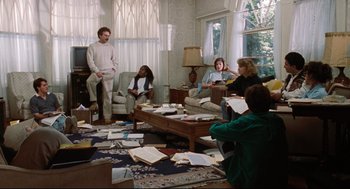Movie still from “Reversal of Fortune” (1990), directed by Barbet Schroeder – A group of people sitting around a living room; Wide shot, High angle