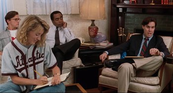 Movie still from “Reversal of Fortune” (1990), directed by Barbet Schroeder – A group of people sitting in a living room next to each other; Medium shot, Over the shoulder angle