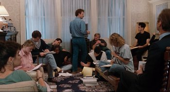 Movie still from “Reversal of Fortune” (1990), directed by Barbet Schroeder – A group of people sitting on the floor in a room; Wide shot, High angle