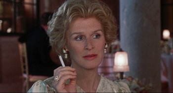 Movie still from “Reversal of Fortune” (1990), directed by Barbet Schroeder – An older woman holding a cigarette in her hand; Close Up shot, Over the shoulder angle
