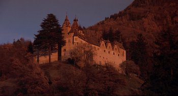 Movie still from “Reversal of Fortune” (1990), directed by Barbet Schroeder – A castle on top of a hill at night time; Extreme Wide shot, Low angle