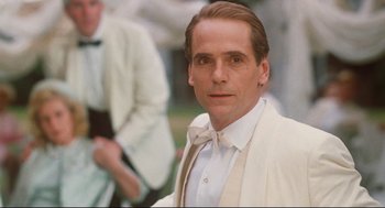 Movie still from “Reversal of Fortune” (1990), directed by Barbet Schroeder – A man in a white suit and bow tie; Close Up shot, Over the shoulder angle