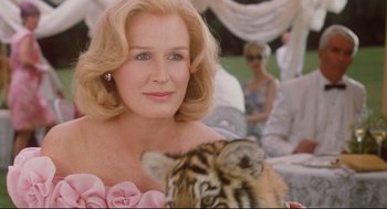 Movie still from “Reversal of Fortune” (1990), directed by Barbet Schroeder – A person holding a tiger cub; Close Up shot, Low angle