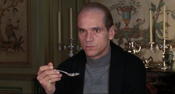 Movie still from “Reversal of Fortune” (1990), directed by Barbet Schroeder – A man holding a spoon in his hand; Close Up shot, Low angle