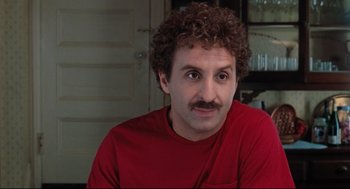 Movie still from “Reversal of Fortune” (1990), directed by Barbet Schroeder – A person wearing a red shirt; Close Up shot, Over the shoulder angle