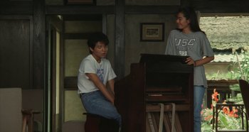 Movie still from “Rhapsody in August” (1991), directed by Akira Kurosawa – Two young men sitting at a piano in a room; Medium shot, High angle