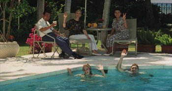 Movie still from “Rhapsody in August” (1991), directed by Akira Kurosawa – A group of people sitting and standing around a swimming pool; Wide shot, High angle