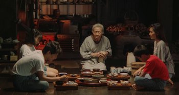 Movie still from “Rhapsody in August” (1991), directed by Akira Kurosawa – An old man sitting in front of a group of people; Wide shot, High angle