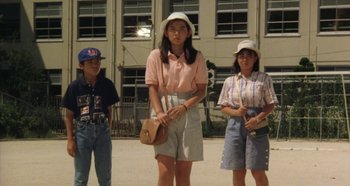 Movie still from “Rhapsody in August” (1991), directed by Akira Kurosawa – A group of people standing next to each other on a street; Medium shot, Low angle