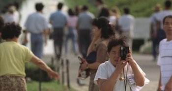 Movie still from “Rhapsody in August” (1991), directed by Akira Kurosawa – A woman taking a picture with a camera; Close Up shot, Over the shoulder angle