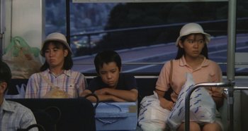 Movie still from “Rhapsody in August” (1991), directed by Akira Kurosawa – A group of people riding on a bus; Medium shot, High angle