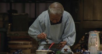 Movie still from “Rhapsody in August” (1991), directed by Akira Kurosawa – An old man in an apron working in a kitchen; Medium shot, High angle
