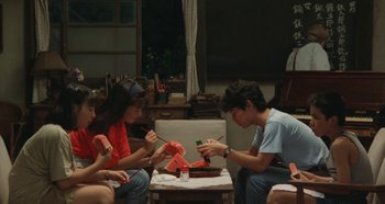Movie still from “Rhapsody in August” (1991), directed by Akira Kurosawa – A group of people sitting around a table; Wide shot, High angle