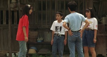Movie still from “Rhapsody in August” (1991), directed by Akira Kurosawa – A group of people standing next to each other in a yard; Wide shot, High angle