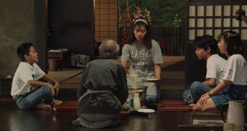 Movie still from “Rhapsody in August” (1991), directed by Akira Kurosawa – A woman sitting on the ground in front of another woman; Wide shot, High angle