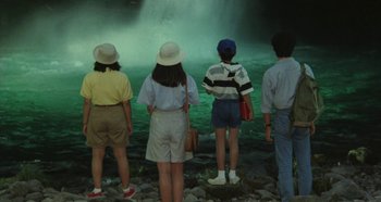 Movie still from “Rhapsody in August” (1991), directed by Akira Kurosawa – A group of people standing in front of a body of water; Wide shot, High angle