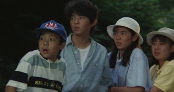 Movie still from “Rhapsody in August” (1991), directed by Akira Kurosawa – A group of young people standing next to each other; Medium shot, High angle