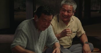 Movie still from “Rhapsody in August” (1991), directed by Akira Kurosawa – Two older men sitting next to each other; Medium shot, Low angle