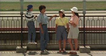 Movie still from “Rhapsody in August” (1991), directed by Akira Kurosawa – A group of people standing next to each other on a bridge; Wide shot, High angle