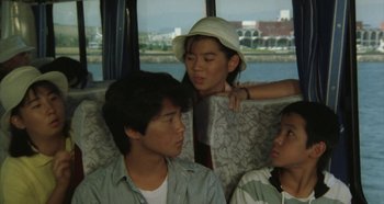 Movie still from “Rhapsody in August” (1991), directed by Akira Kurosawa – A group of people sitting on a bus; Medium shot, High angle