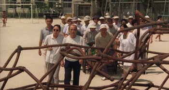 Movie still from “Rhapsody in August” (1991), directed by Akira Kurosawa – A group of people standing next to each other on a street; Wide shot, High angle