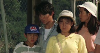 Movie still from “Rhapsody in August” (1991), directed by Akira Kurosawa – A group of people standing next to each other on a field; Medium shot, High angle