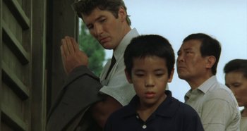 Movie still from “Rhapsody in August” (1991), directed by Akira Kurosawa – A man and a boy are standing next to each other; Close Up shot, Low angle