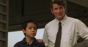 Movie still from “Rhapsody in August” (1991), directed by Akira Kurosawa – A man standing next to a boy in a room; Close Up shot, Low angle