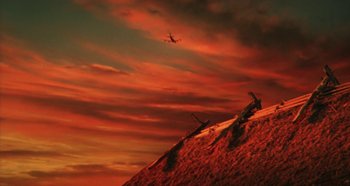 Movie still from “Rhapsody in August” (1991), directed by Akira Kurosawa – An airplane is flying in the sky at sunset; Extreme Wide shot, Low angle