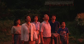 Movie still from “Rhapsody in August” (1991), directed by Akira Kurosawa – A group of people looking up into the sky at night; Medium shot, Low angle