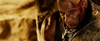 Movie still from “Riddick” (2013), directed by David Twohy – A man's face with blood all over his face; Close Up shot, Over the shoulder angle
