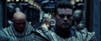 Movie still from “Riddick” (2013), directed by David Twohy – A person wearing armor; Close Up shot, Over the shoulder angle