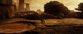 Movie still from “Riddick” (2013), directed by David Twohy – A group of people standing on top of a dirt field; Extreme Wide shot, High angle