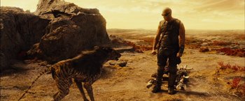 Movie still from “Riddick” (2013), directed by David Twohy – A man standing next to a dog on top of a hill; Wide shot, Over the shoulder angle