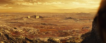 Movie still from “Riddick” (2013), directed by David Twohy – An image of an alien landscape with a lighthouse in the distance; Extreme Wide shot, High angle