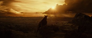 Movie still from “Riddick” (2013), directed by David Twohy – A dog standing on top of a beach near the ocean; Extreme Wide shot, High angle