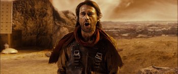Movie still from “Riddick” (2013), directed by David Twohy – A man with long brown hair and a brown scarf; Close Up shot, Low angle