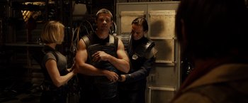 Movie still from “Riddick” (2013), directed by David Twohy – A man and a woman in black leather vests; Medium shot, Over the shoulder angle