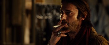 Movie still from “Riddick” (2013), directed by David Twohy – A person smoking a cigarette; Close Up shot, Over the shoulder angle