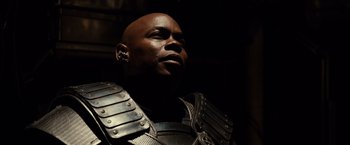 Movie still from “Riddick” (2013), directed by David Twohy – A bald man wearing armor looking up into the sky; Close Up shot, Low angle