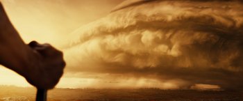 Movie still from “Riddick” (2013), directed by David Twohy – A very large cloud in the sky over a field; Extreme Wide shot, Low angle