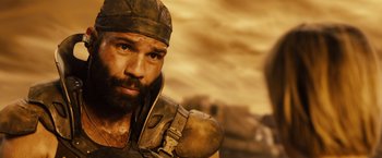 Movie still from “Riddick” (2013), directed by David Twohy – A man with a beard and a helmet on; Close Up shot, Low angle