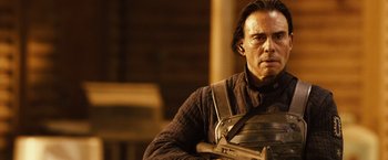 Movie still from “Riddick” (2013), directed by David Twohy – A person holding a gun; Close Up shot, Over the shoulder angle