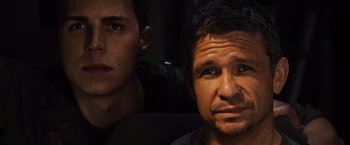 Movie still from “Riddick” (2013), directed by David Twohy – A man and a young man are looking at the camera; Close Up shot, Over the shoulder angle
