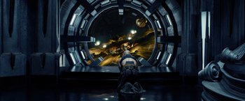 Movie still from “Riddick” (2013), directed by David Twohy – A man sitting in front of a large window; Wide shot, High angle