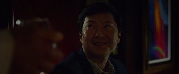 Movie still from “Ride Along 2” (2016), directed by Tim Story – A person wearing a suit and smiling; Close Up shot, Over the shoulder angle