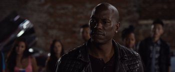 Movie still from “Ride Along 2” (2016), directed by Tim Story – A man in a leather jacket looking to his left; Close Up shot, Over the shoulder angle