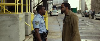 Movie still from “Ride Along 2” (2016), directed by Tim Story – Two police officers talking on the side of the street; Medium shot, Over the shoulder angle